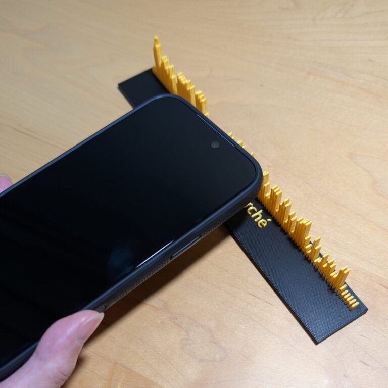 卓上型の声の彫刻の台座にスマホの上部をかざしている様子